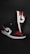 A pair of stylish athletic shoes in black, white, and red colors with distinctive branding. The shoes are positioned against a dark background, showcasing their sleek design and detailed craftsmanship.