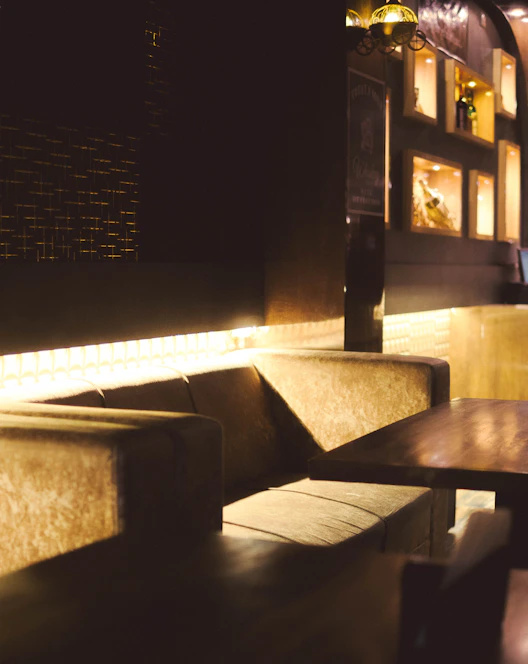 A bright, modern finished basement with cozy seating, sleek flooring, and warm lighting.