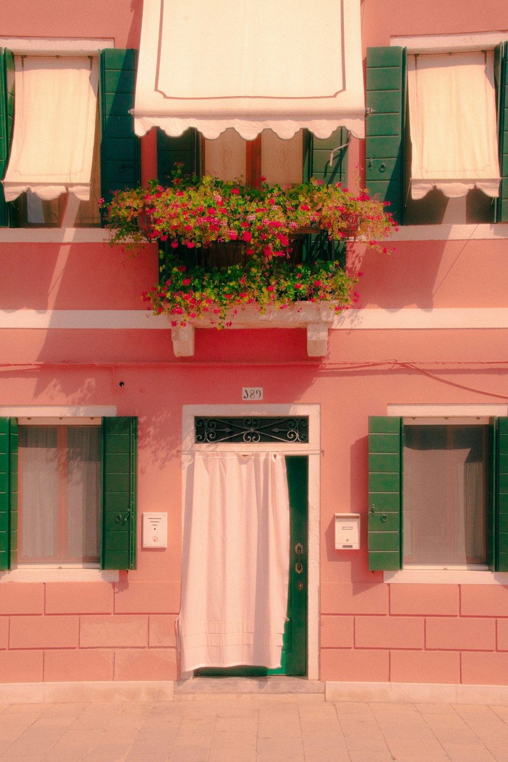 a building with a door and a window with flowers on it