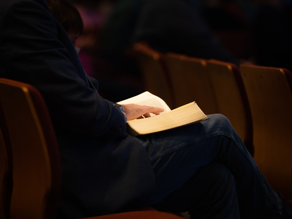 a person sitting in a chair reading a book