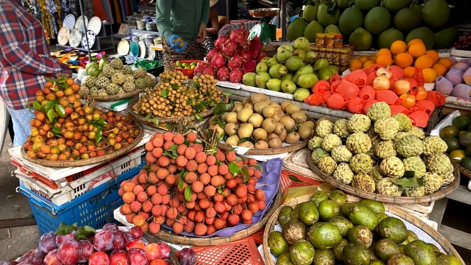 A bustling Malaysian fruit market stall filled with ripe tropical fruits ready for export.