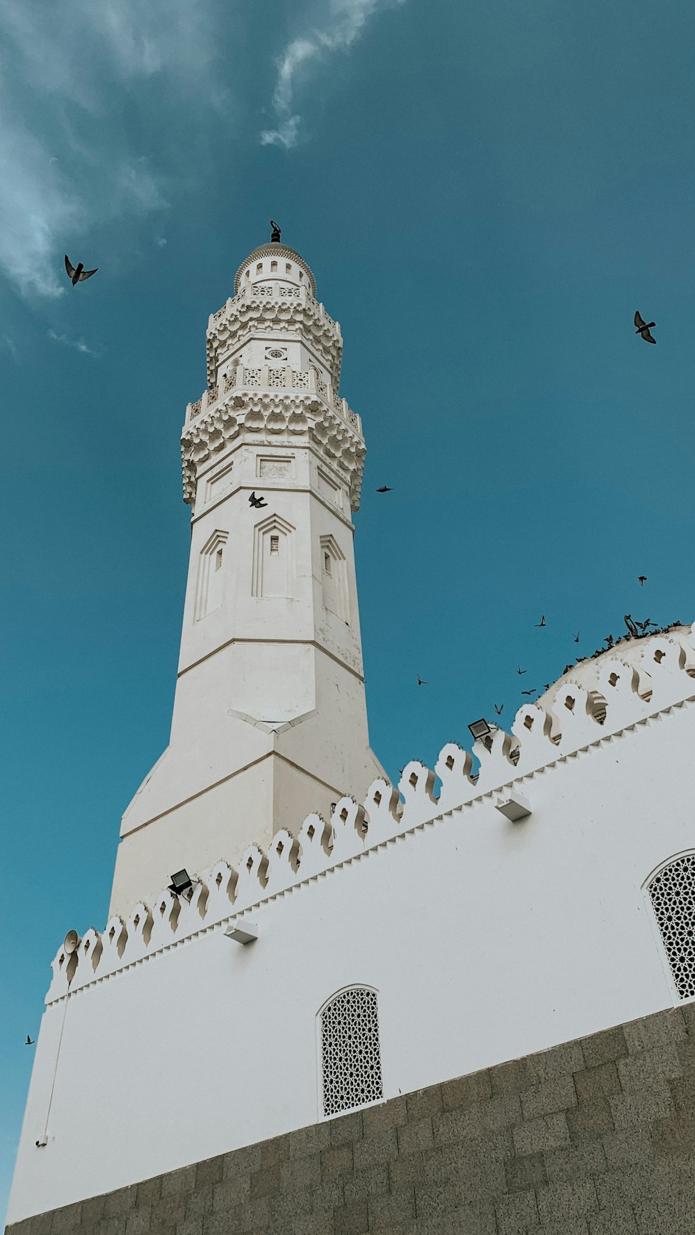 a clock tower with birds flying around