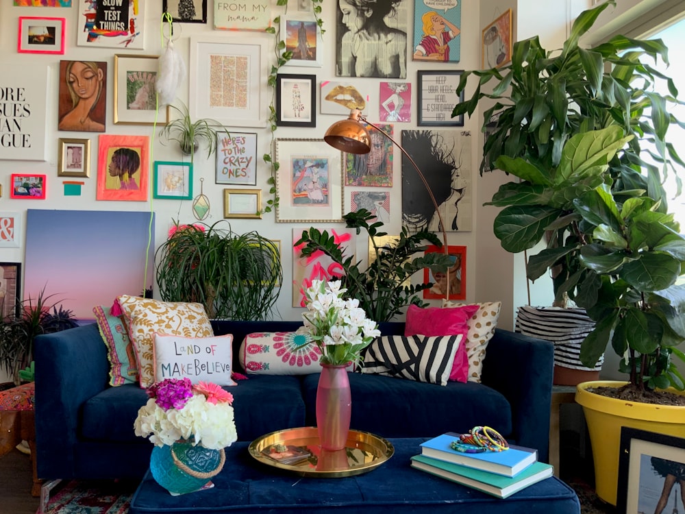 una sala de estar con un sofá azul y un jarrón con flores