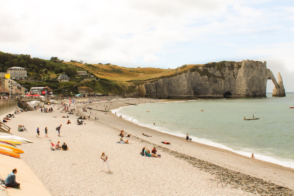 a beach with people and a cliff