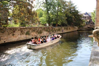 A group of happy passengers enjoying a peaceful cruise on an aqua current electric canal boat.