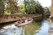 A group of friends laughing on a scenic boat ride.
