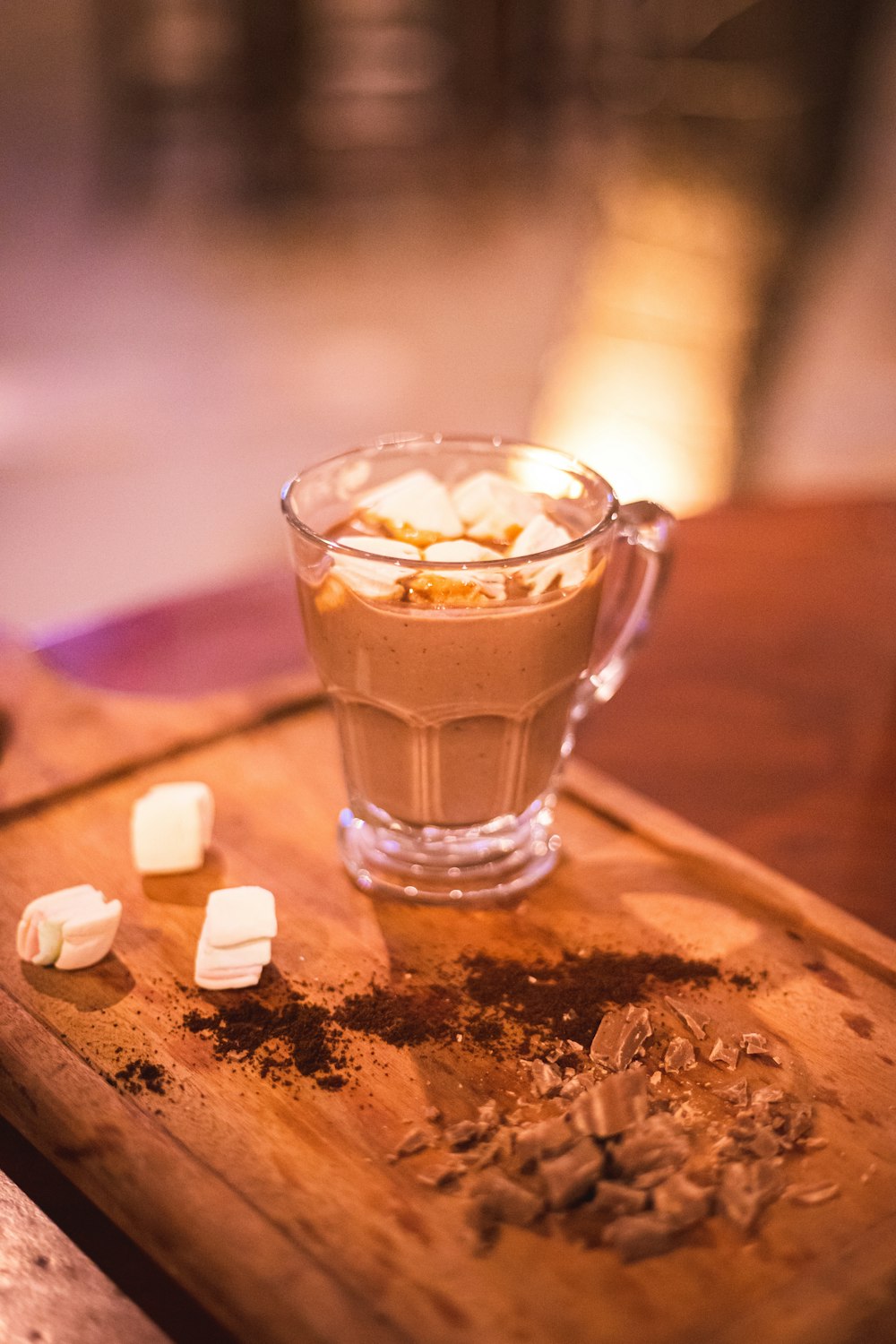 a glass of liquid with a slice of cheese on a wood surface