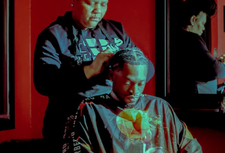 A skilled stylist braiding intricate African patterns in a cozy salon setting.