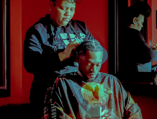 A skilled stylist braiding intricate African patterns in a cozy salon setting.