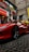 A satisfied customer standing next to a shiny Ferrari.