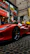 Happy customer standing beside a sleek Ferrari with a Rossoveloce package in hand.