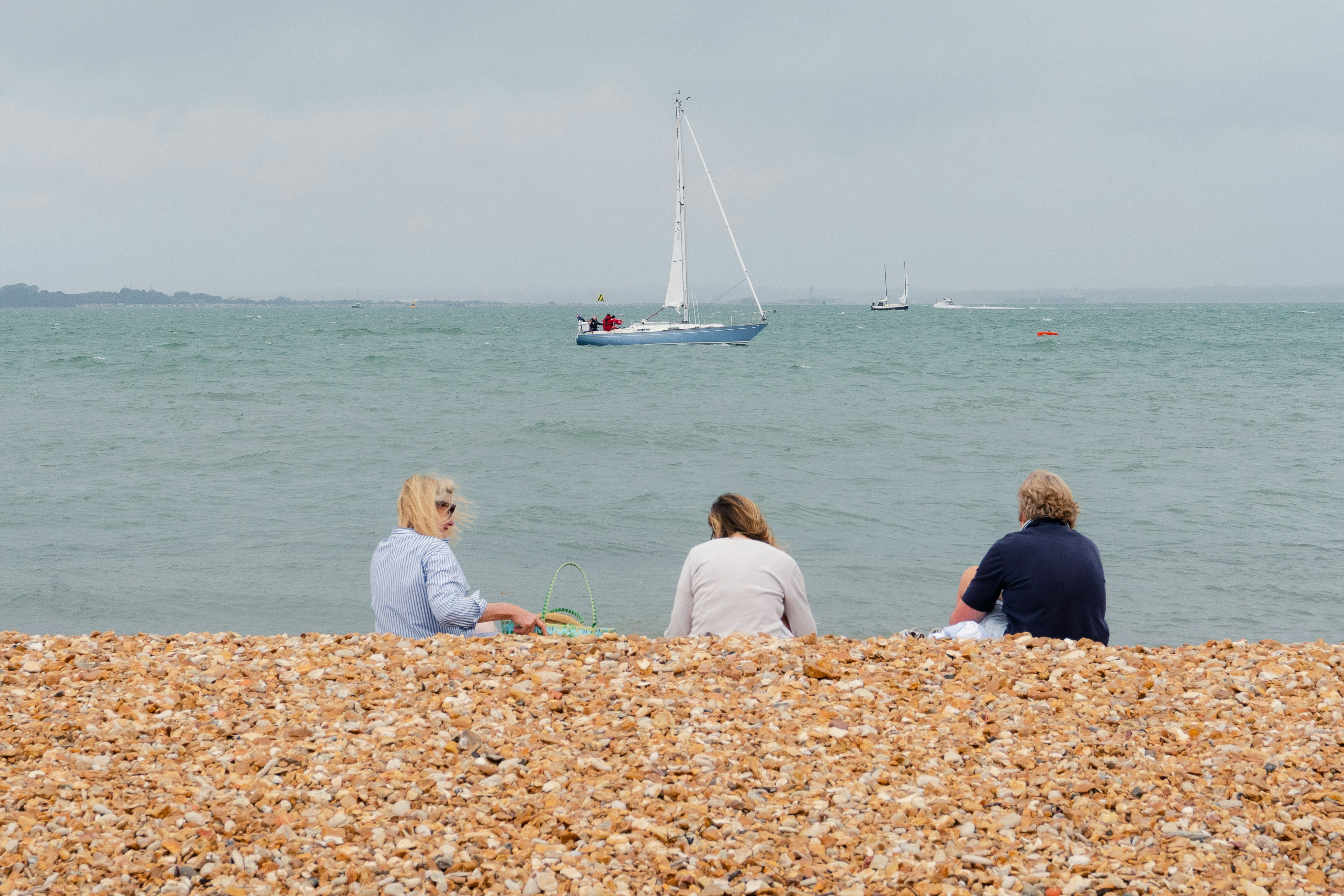 Three friends enjoy the view of the Solent on a Sunday.
