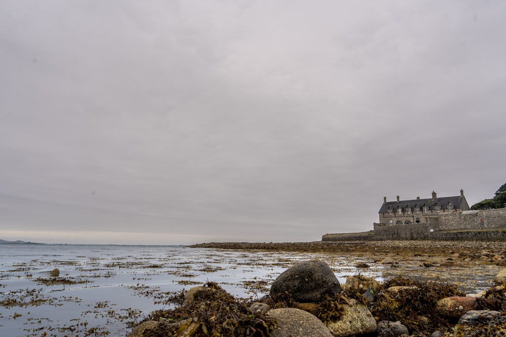 a rocky beach with a castle on the shore