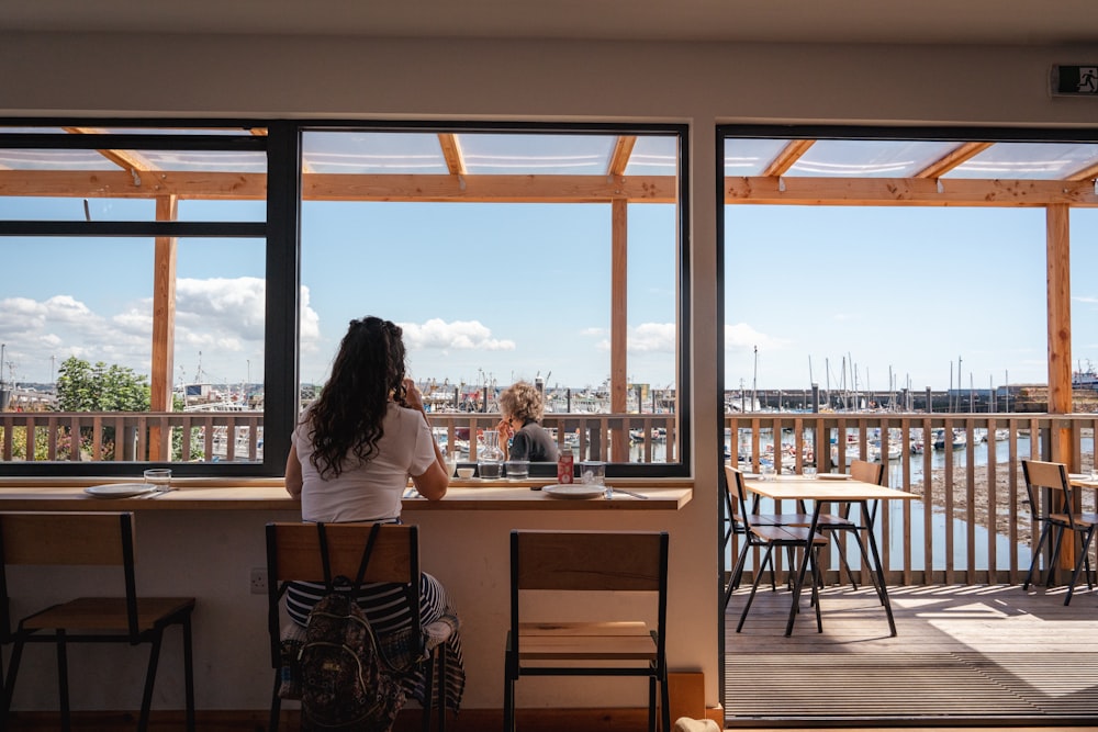 a couple of people sitting at a table looking out at the water