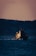Image of a ship navigating through calm waters during sunset.