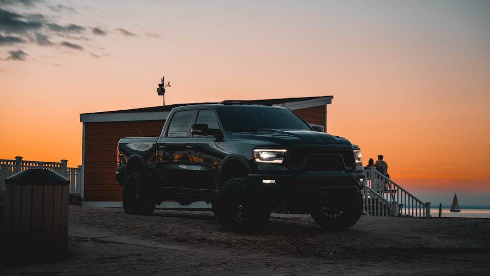 a black truck parked on a beach