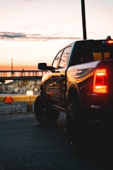 A sleek pickup truck parked on a highway at sunset, ready for auction.