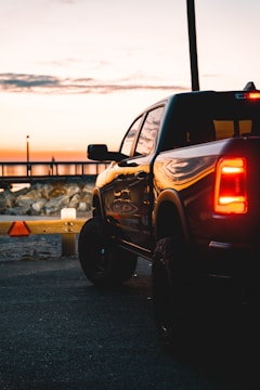 A sleek pickup truck parked on a highway at sunset, ready for auction.