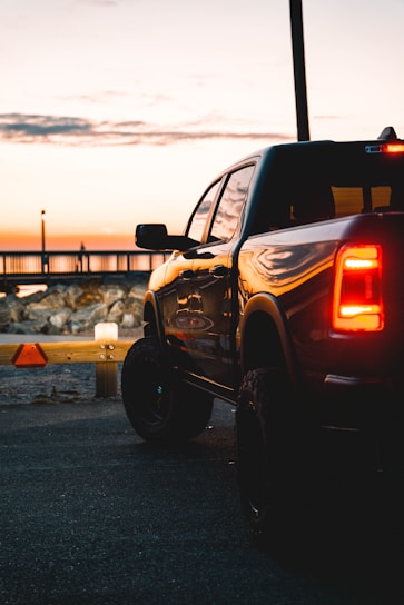 A reliable pickup truck parked in front of a cityscape during sunset.