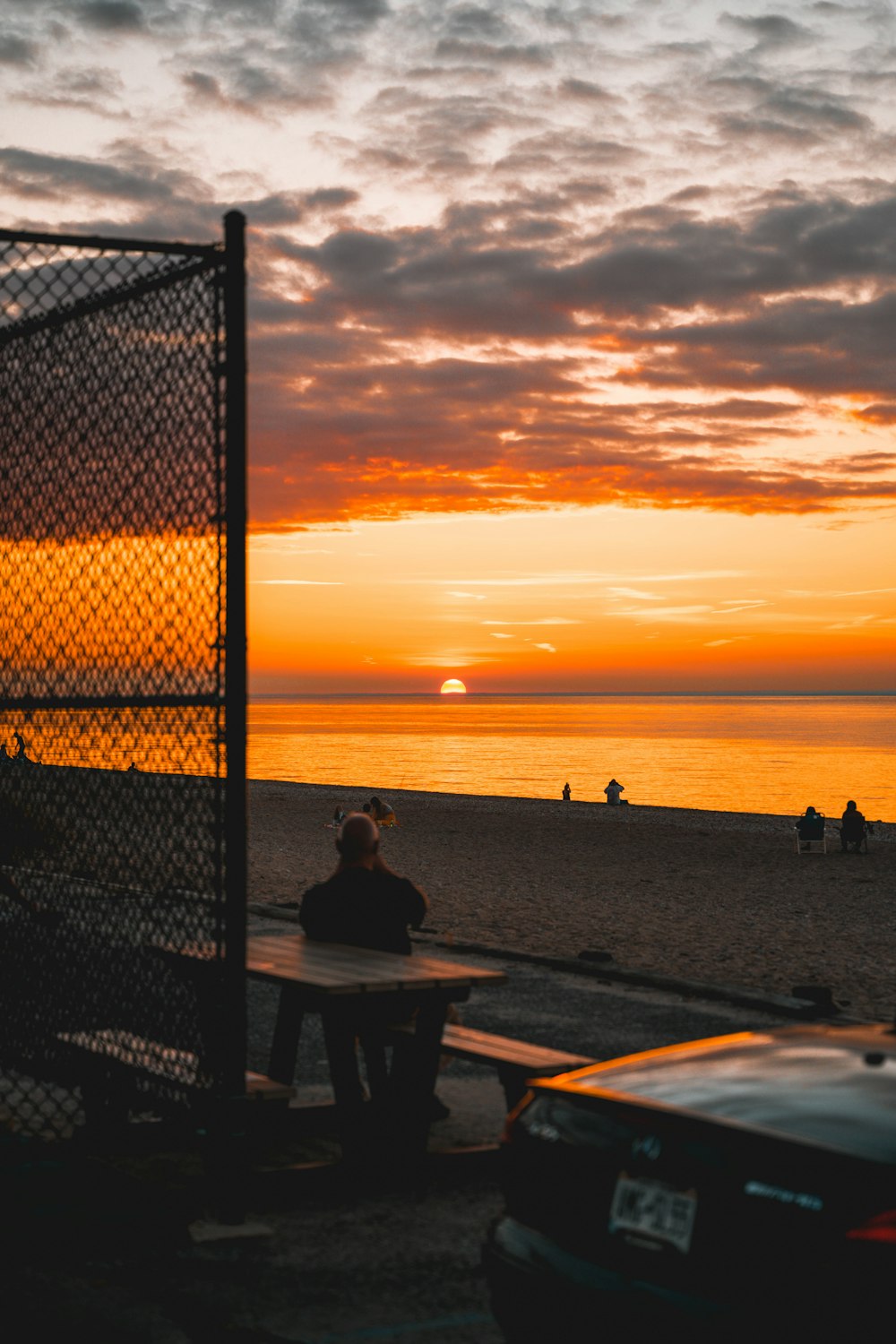 a person sitting on a bench at the beach
