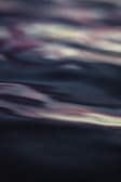 Abstract waves of sound visualized as gentle ripples on a dark surface.