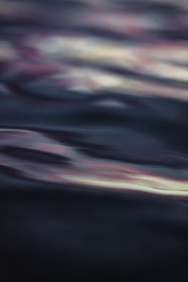 Abstract waves of sound visualized as gentle ripples on a dark surface.