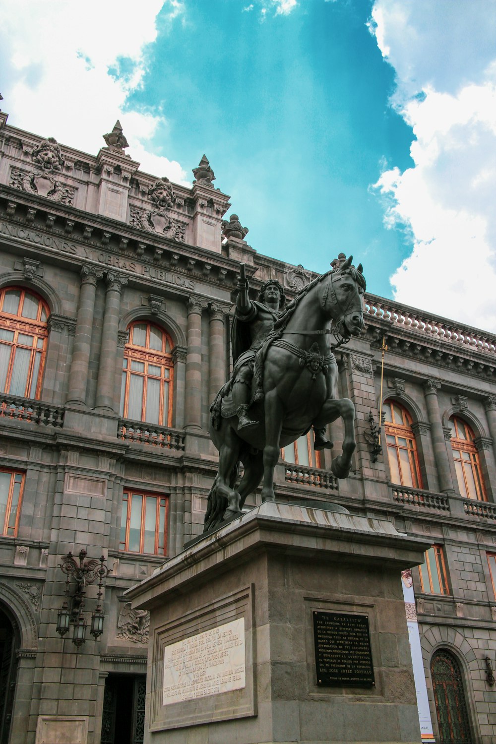 a statue of a person on a horse in front of a building