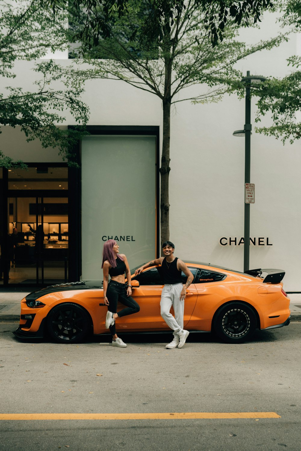 a man and woman leaning against a car