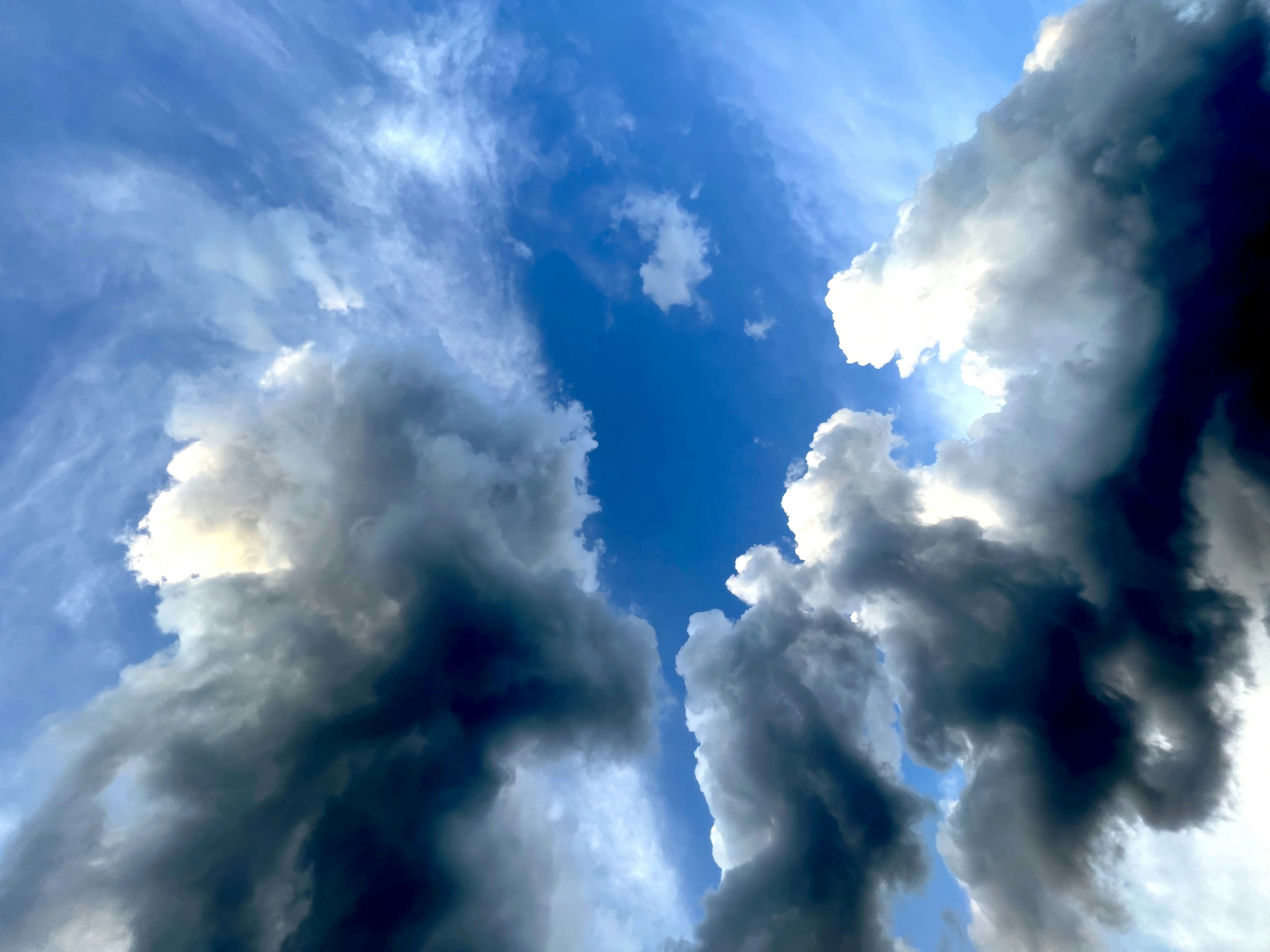 Split sky showing stormy dark clouds on one side and clear sunny sky on other, dramatic contrast