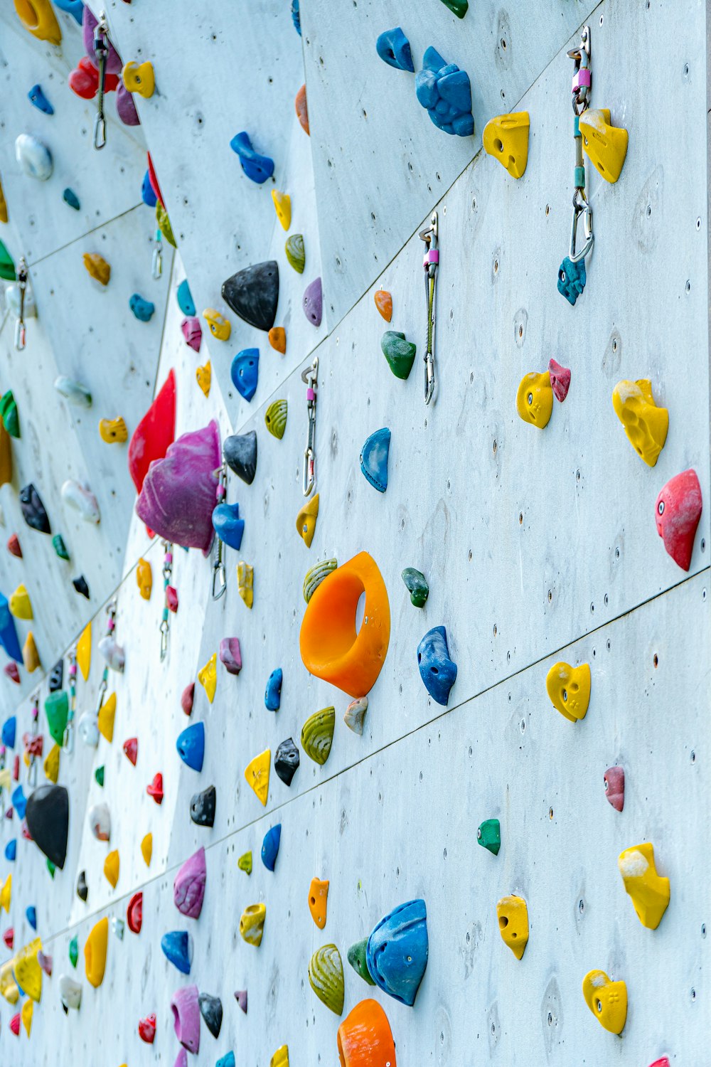 a climbing wall with colorful climbing gear