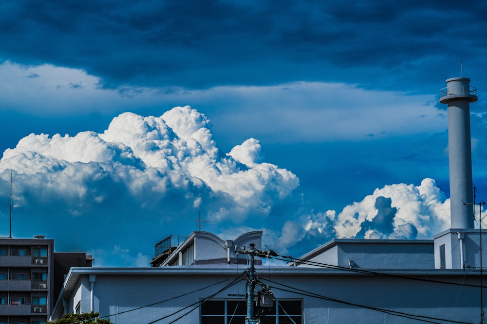 a building with smokestacks and a blue sky with clouds