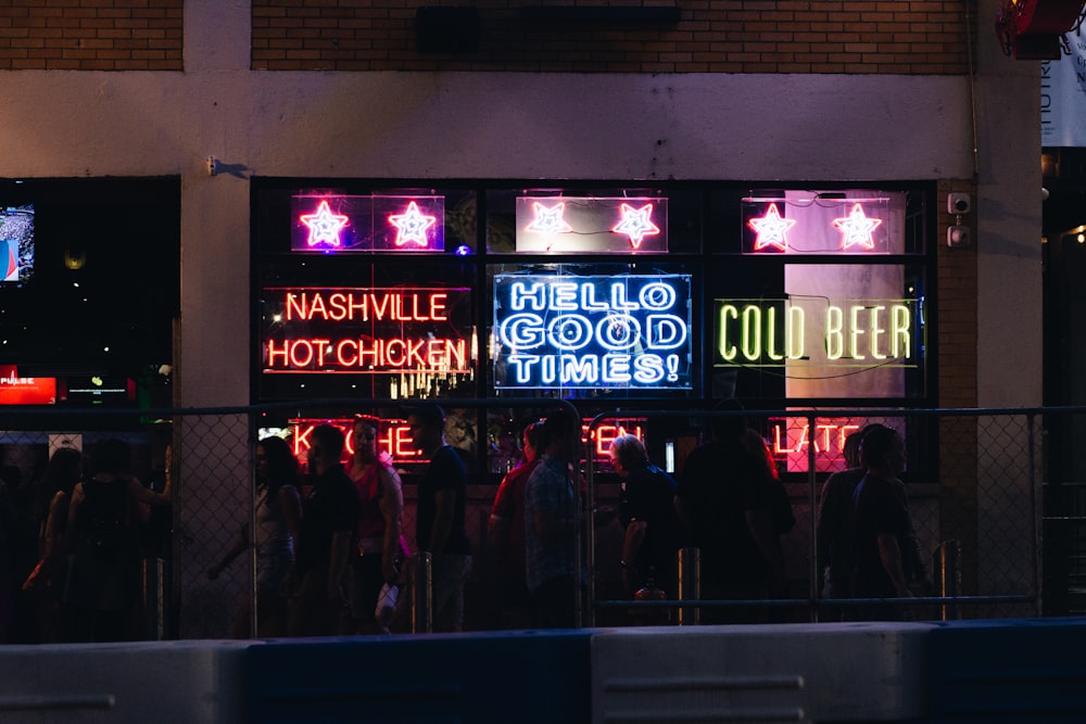 a group of people standing in front of a building with neon signs