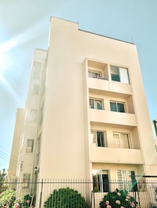 A friendly property manager inspecting a residential block exterior on a sunny day.