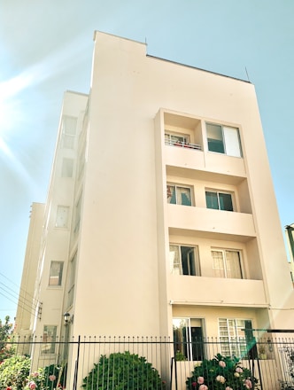 A friendly property manager inspecting a well-maintained residential building on a sunny day.