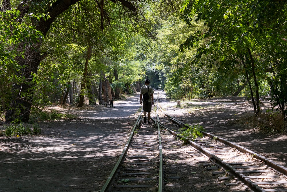 una persona caminando sobre una vía férrea