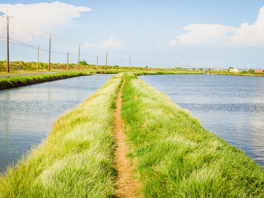 a long straight road next to a body of water