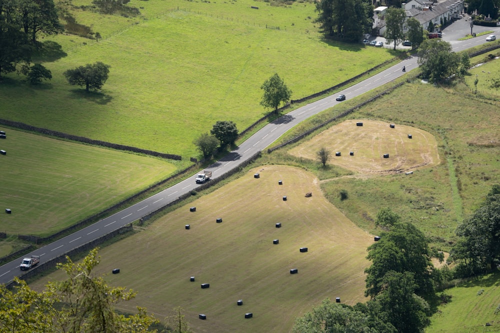 Un grand champ avec une route et des voitures dessus