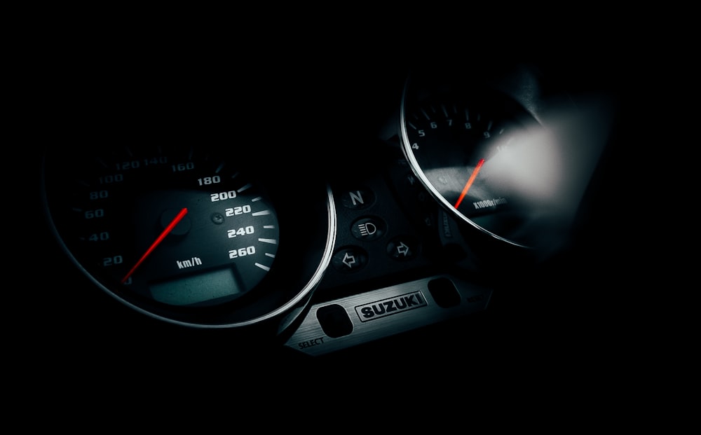 a car dashboard with a couple of gauges and a couple of black and white dials