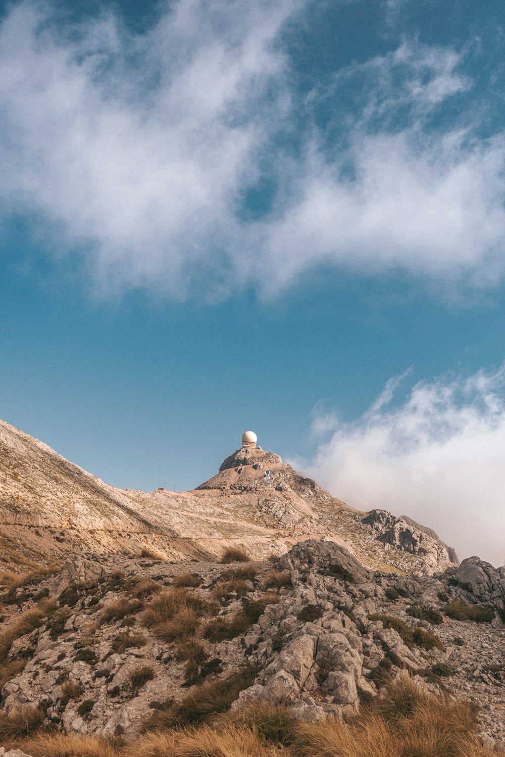 a rocky mountain with a blue sky