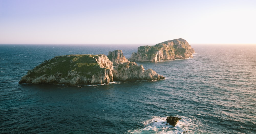 a group of large rocks in the ocean