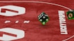 Two green dice with rounded edges are positioned on a red surface that seems to be part of a game board. The surface has white text and numbers on it, including the word 'LUCKYTOPSPIN' in capital letters.