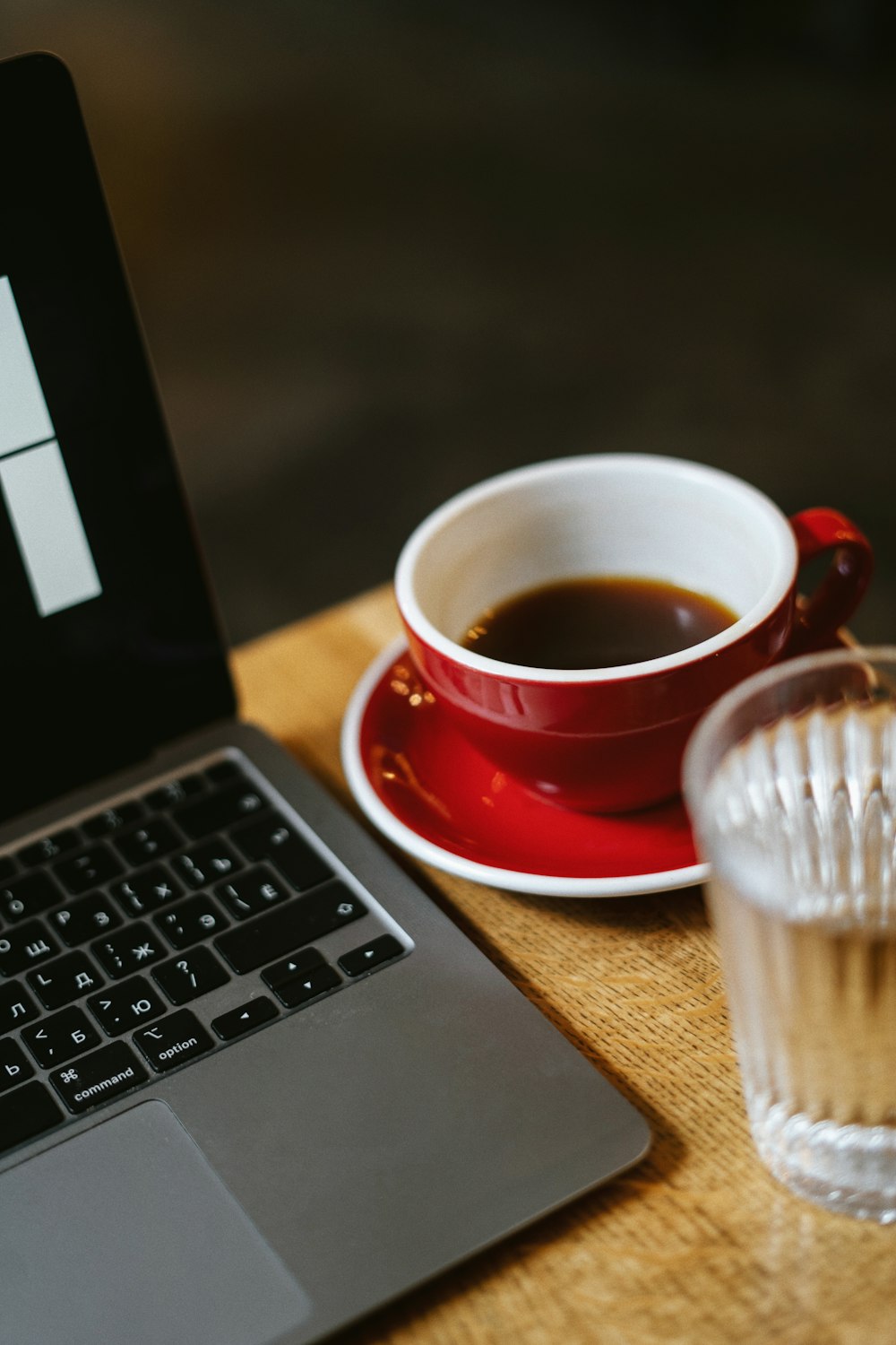 a cup of coffee next to a laptop