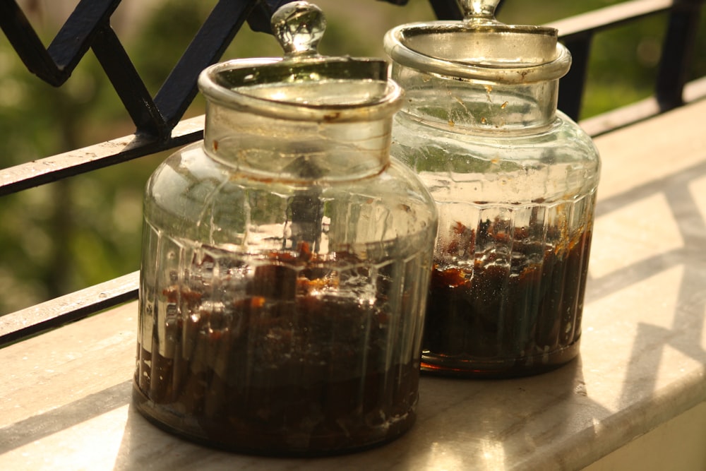 a couple glass jars with brown liquid