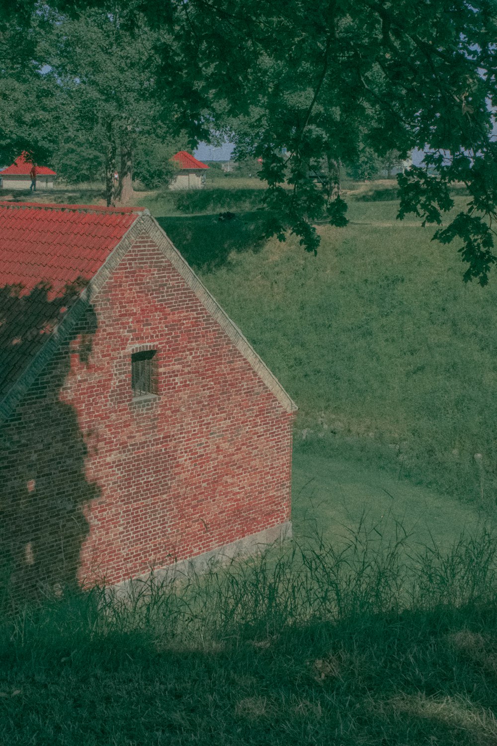 a brick building in a grassy field