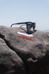 a pair of sunglasses on a rock