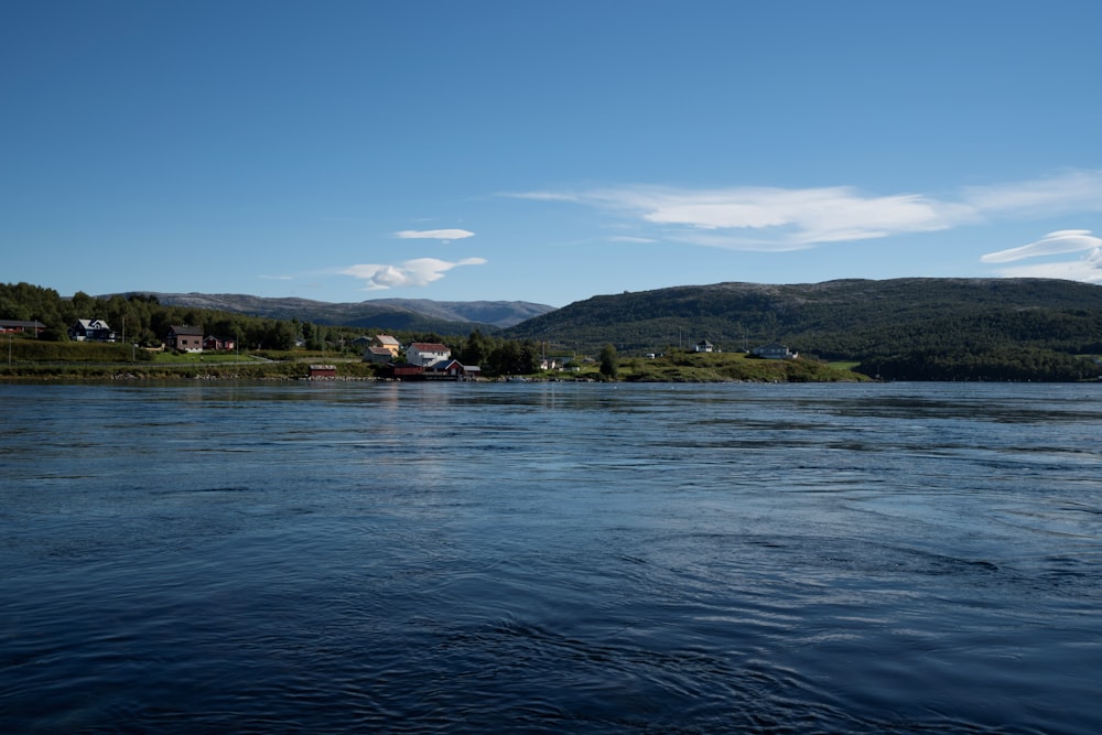 a body of water with a boat in it and hills in the back