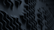 Abstract wave-like patterns create a textured surface with smooth curves. The dark tones convey a sense of depth, producing a visually intriguing design reminiscent of sand dunes or fabric folds.