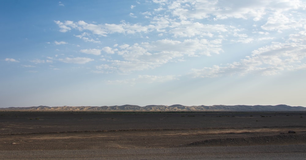 a large flat area with hills in the background