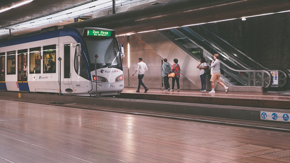 a group of people walking on a platform next to a train