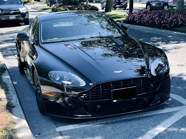 A sleek car parked on a sunny street in Qatar, showcasing its shiny exterior.